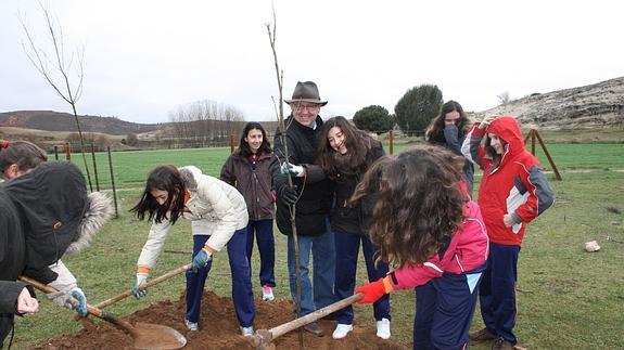 Varios escolares, junto a López-Escobar, plantan un árbol.El Norte
