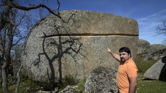 José Miguel Labrador señala la hendidura que se realizaba para extraer los bloques de un bolo de granito en la cantera de ‘El Berrocal’, en Ortigosa del Monte. 
