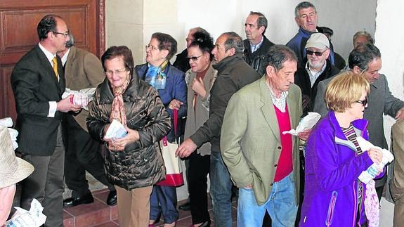 El alcalde de Torquemada, a la izquierda, en el reparto del pan y quesillo el año pasado.