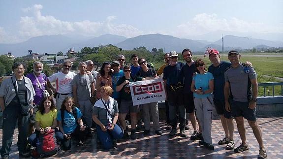 Las senderistas segovianas Pepa Santos (centro, con blusa en tonos rojos) y Begoña Gómez (izquierda, agachada), en la foto del grupo enviada antes de viajar a Katmandú. A la derecha, una casa destrozada ya en la capital nepalí.