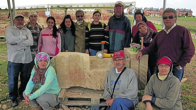 Gran parte de los escultores participantes en esta edición de la feria de Villamayor junto a Valeriano Hernández, coordinador internacional.