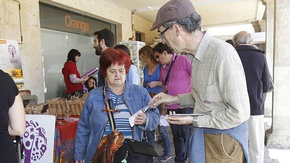 Un integrante de la plataforma Ganemos reparte folletos en la Plaza Mayor.