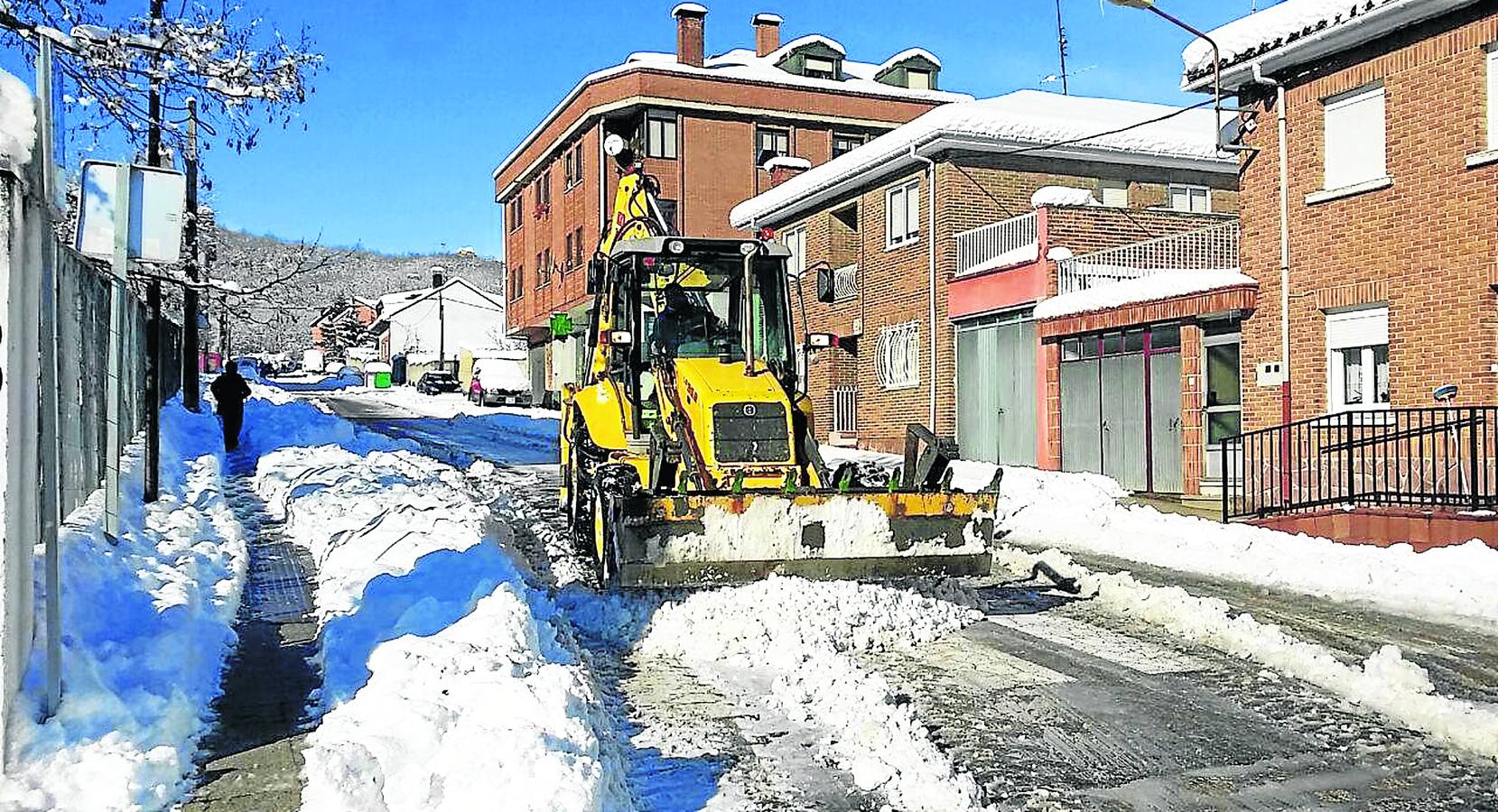 Una pala retira la nieve en una calle de Guardo durante el temporal de nieve.