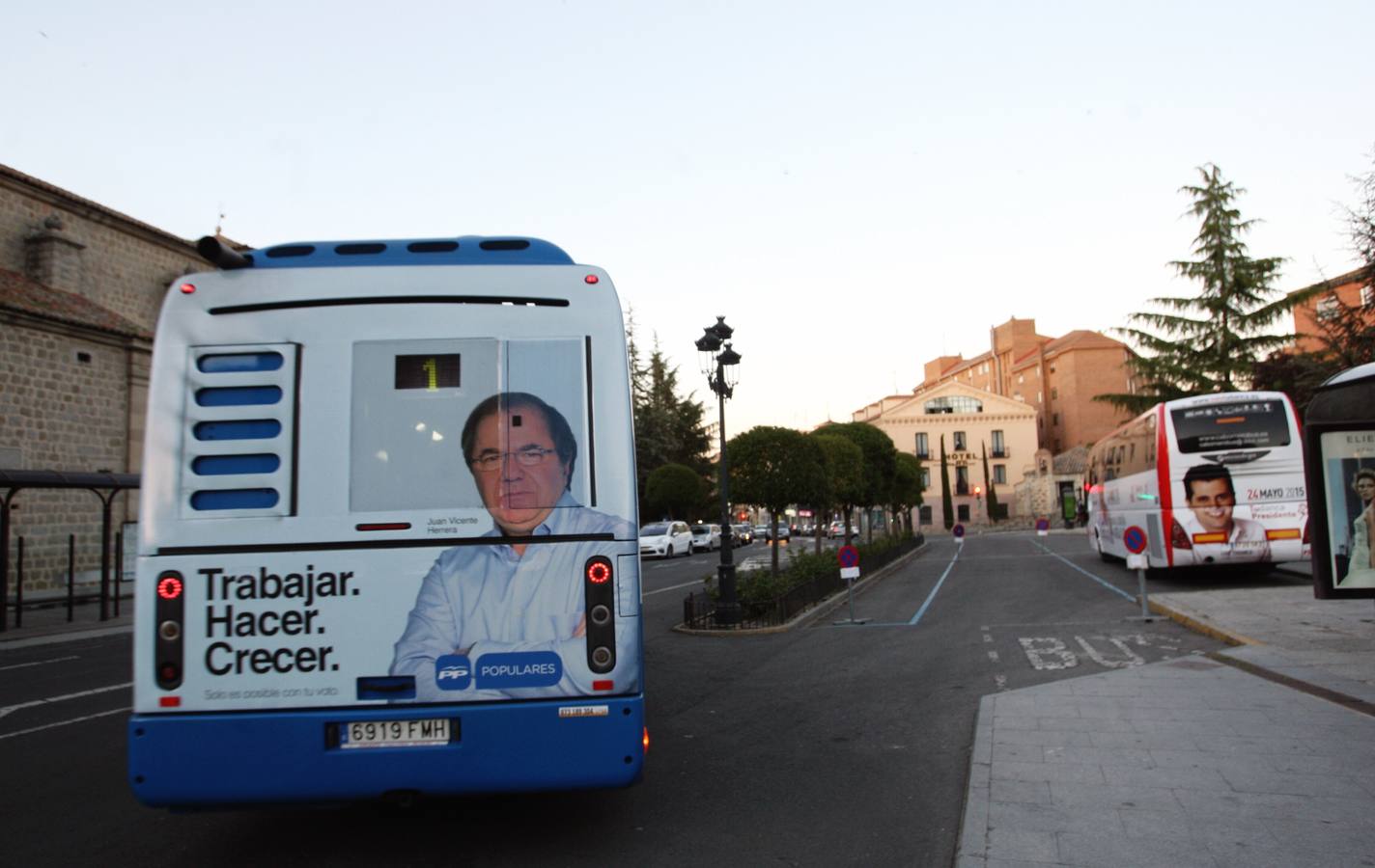 Un autobús municipal con publicidad del candidato popular a la Presidencia de la Junta, Juan Vicente Herrera, pasa junto al autobús de la caravana socialista de Luis Tudanca en Ávila. 