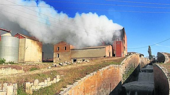 Intensa columna de humo que salía ayer de la fábrica, junto al Canal de Castilla.
