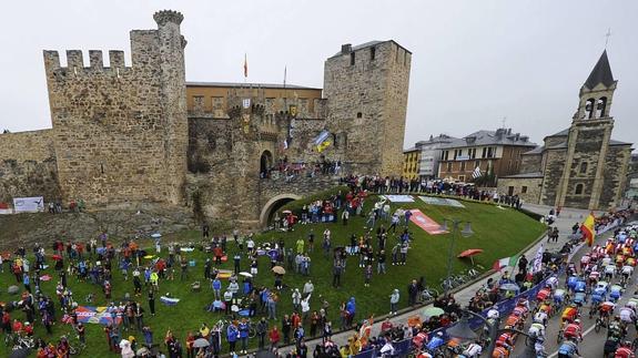 El pelotón pasa por el Castillo templario de Ponferrada durante la prueba.