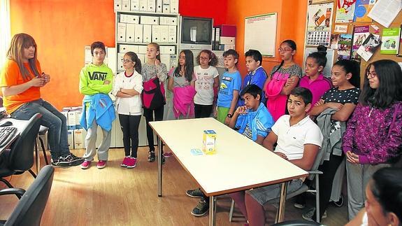 Una monitora dirige una actividad con un grupo de escolares.