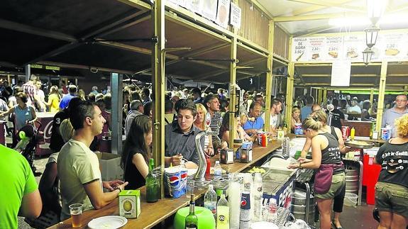 Varios clientes toman algo en una de las barras de las casetas de la Feria de Día
