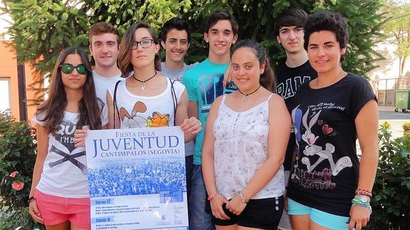 María Marugán posa con el cartel de la fiesta de este año junto al resto de los quintos, excepto Miguel Ferri. 