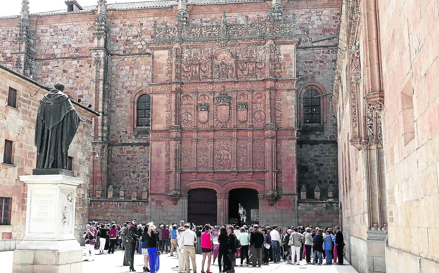 Numerosos turistas contemplan la fachada plateresca de la Universidad de Salamanca.