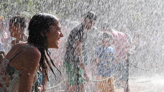 Unos jóvenes se empapan en los juegos de agua de las fuentes monumentales. Antonio Tanarro 
