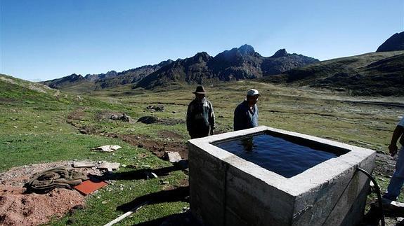Dos hombres junto a un depósito de agua. 