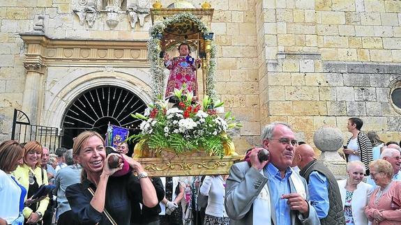 La concejala de Cultura del Ayuntamiento de Palencia, Carmen Fernández Caballero, baila la talla del Niño Jesús junto al alcalde de Astudillo, Luis Santos, ayer, delante de la iglesia de Santa Eugenia. 
