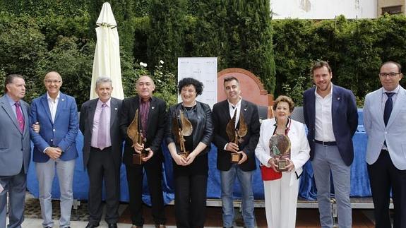 Los premiados en el acto junto a las autoridades que presidían la entrega. 