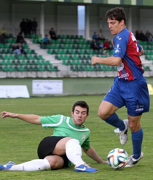 Dani Lazaro conduce el balón ante la oposición de un rival en un partido con la Segoviana. 
