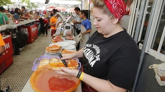 Preparación de pan con tomate en la caseta gastronómica de Cataluña.