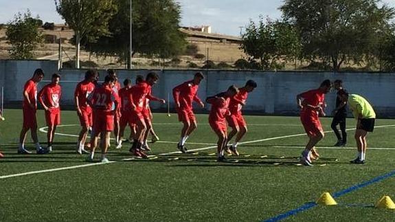 Los jugadores del Guijuelo durante un entrenamiento de esta semana en el Municipal con las paredes del campo recién pintadas. 