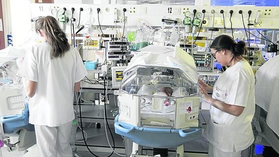 Personal sanitario controla a dos bebés en la UCI Pediátrica el Complejo Universitario de Salamanca.
