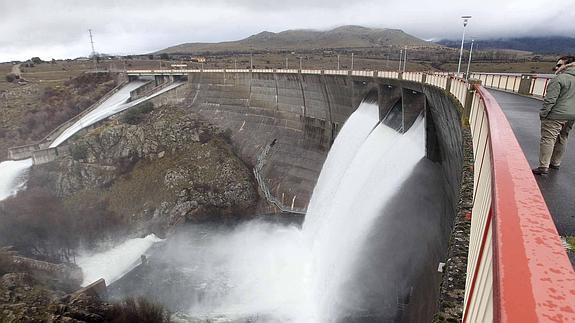 Presa del Pontón Alto en invierno, con el agua rebosando arriba y uno de los desagües inferiores abierto.