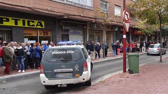Decenas de vecinos observan el traslado de los detenidos el el número 40 de la calle Embajadores. 