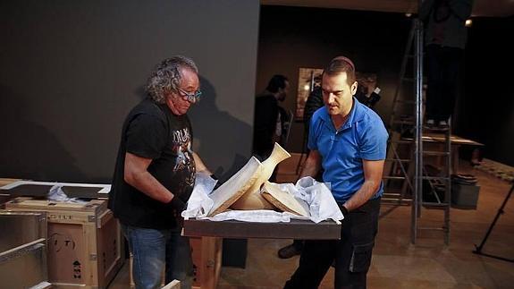 Dos técnicos trasladan una de las cerámicas de Barceló. 