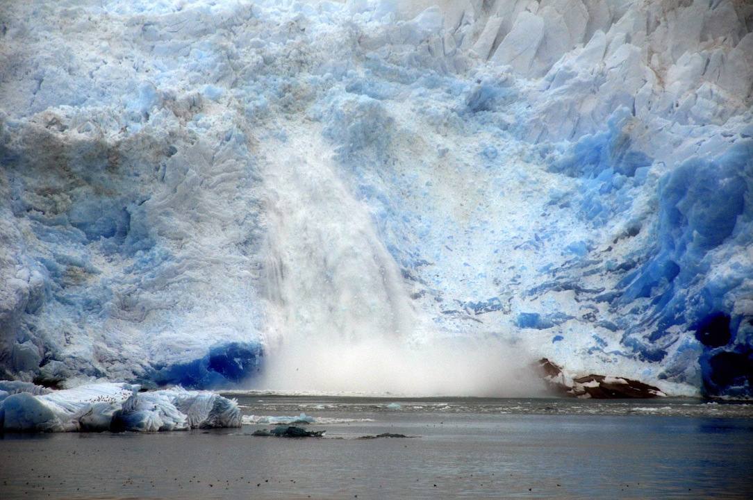 Un río desemboca en el mar por debajo del un glaciar en la costa de Groenlandia. 