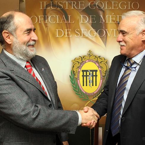 Javier Alcaraz y Enrique Guilabert se estrechan la mano, este miércoles, en la sede del Colegio de Médicos. 