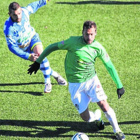 Romero conduce el balón presionado por un rival de la Arandina.