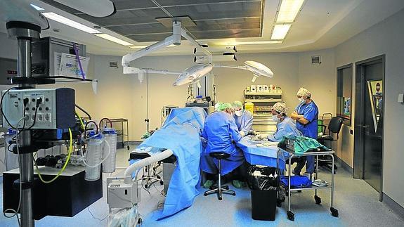 Un equipo de cirujanos está preparado para operar en un quirófano de un complejo hospitalario. 