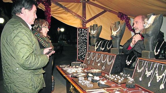 El alcalde de Cuéllar, a la izquierda, durante la inauguración del mercadillo. 