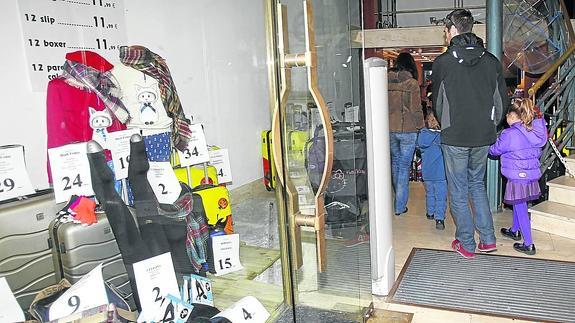 Una familia entra en uno de los comercios que abrieron este lunes sus puertas. 