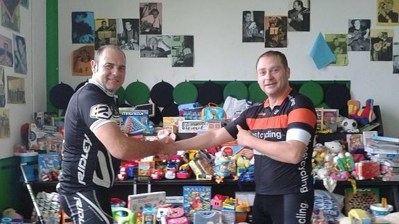 Dos de los participantes en el maratón solidario de ciclo indoor organizado por Xpinning Ciclo Indoor con los juguetes conseguidos en Portillo. 