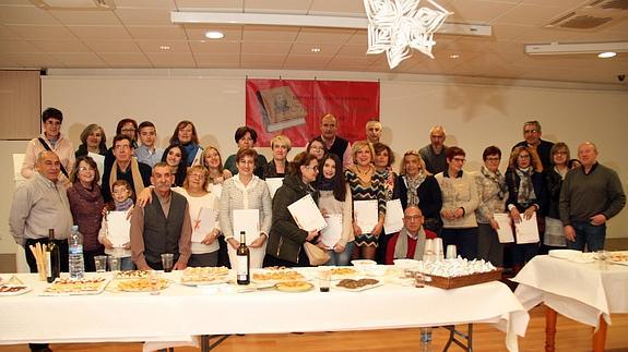 Los vecinos, muchos de ellos con el recetario en la mano, posan durante el encuentro celebrado el sábado por la noche. 