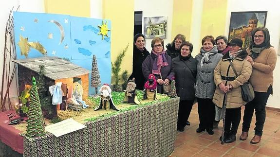 Vecinas de Paredes de Nava, con el belén que han elaborado con materiales reciclados. 