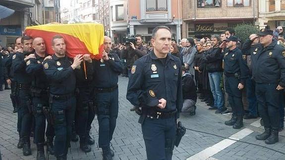 Los compañeros del agente fallecido portan su féretro. 