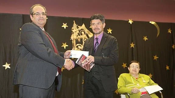 Rendey Horacio Ortiz Rodríguez, ganador del certamen, recoge el premio de manos de Fernando Calvo en presencia de Juliana Panizo.