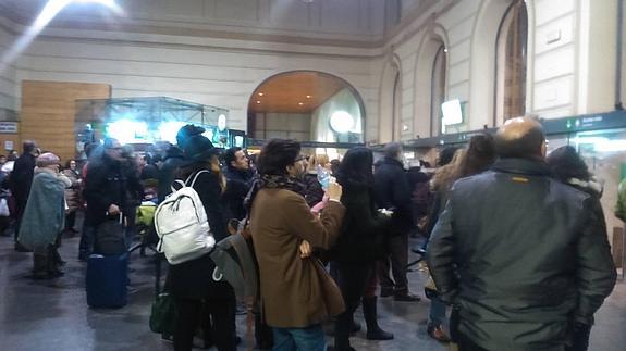 Varias personas observan las pantallas informativas de la estación de tren de Valladolid a la espera de noticias sobre la incidencia.