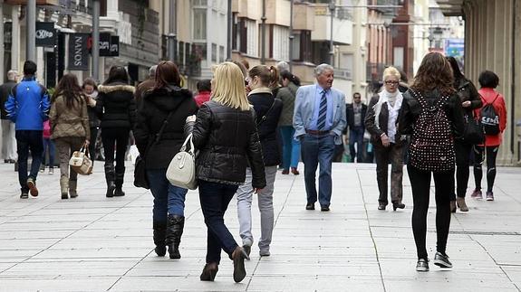 Varias personas caminan por la Calle Mayor. 