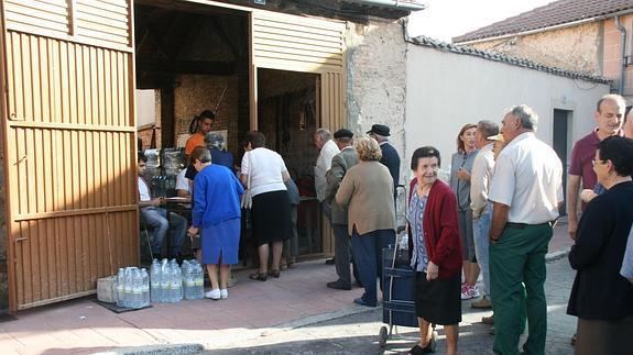 Cola de vecinos para recoger agua embotellada, una imagen que ya no se repetirá. M. R.