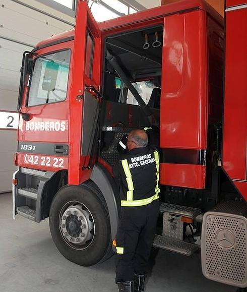 Un agente de los Bomberos de Segovia e sube a uno de los camiones de extinción de incendios. 