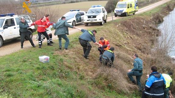 Los guardias civiles y personal de emergencias colaboran en el rescate del menor. 