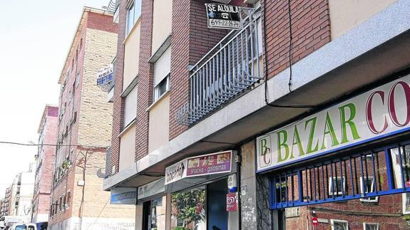 Un bloque de viviendas con un anuncio que publicita pisos en alquiler. 