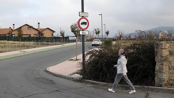 Una mujer se dirige a una de las antradas a la urbanización El Carrascalejo. Antonio de Torre