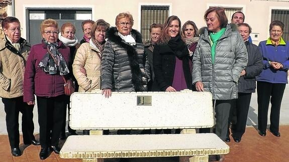 Las representantes de Femur, con la alcaldesa, junto a uno de los bancos instalados. 