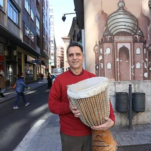 Abraham Adeli, con un jembé a las puertas de su tienda Samarcanda, con el grafiti que remite al Taj Mahal que identifica su negocio. 