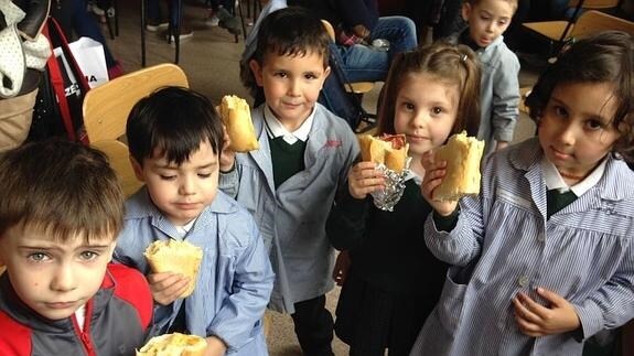 Varios niños disfrutan de su bocadillo solidario.