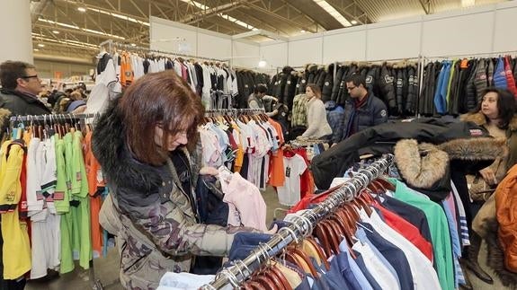 Una mujer mira unas camisas en uno de los expositores. 