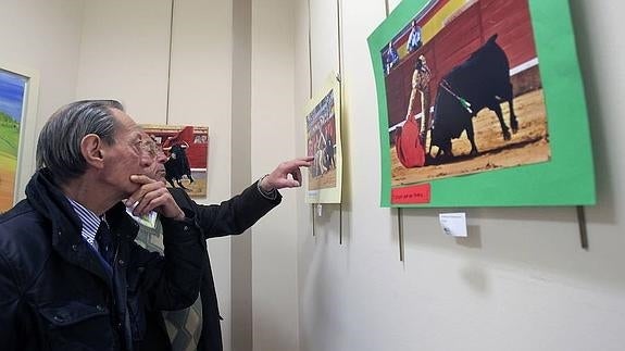 José María González contempla una imagen en una exposición de fotografía taurina.