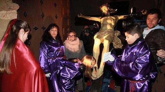 Un momento del besapiés con la talla del Santo Cristo de San Marcos en la puerta de la iglesia parroquial. 