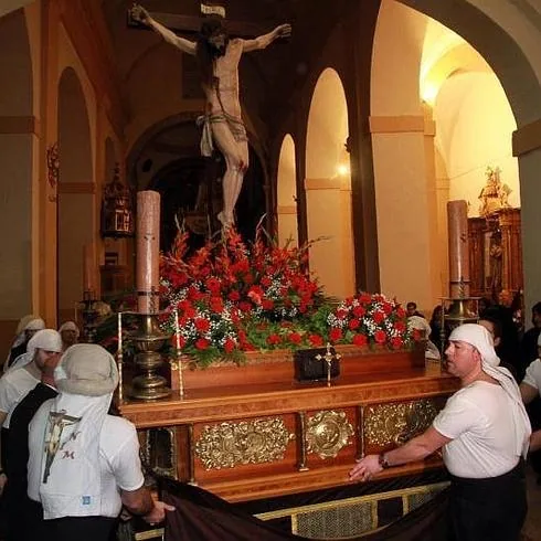 Costaleros llevan a pulso el trono del Cristo de la Esperanza instantes antes de salir de Santa Eulalia. 